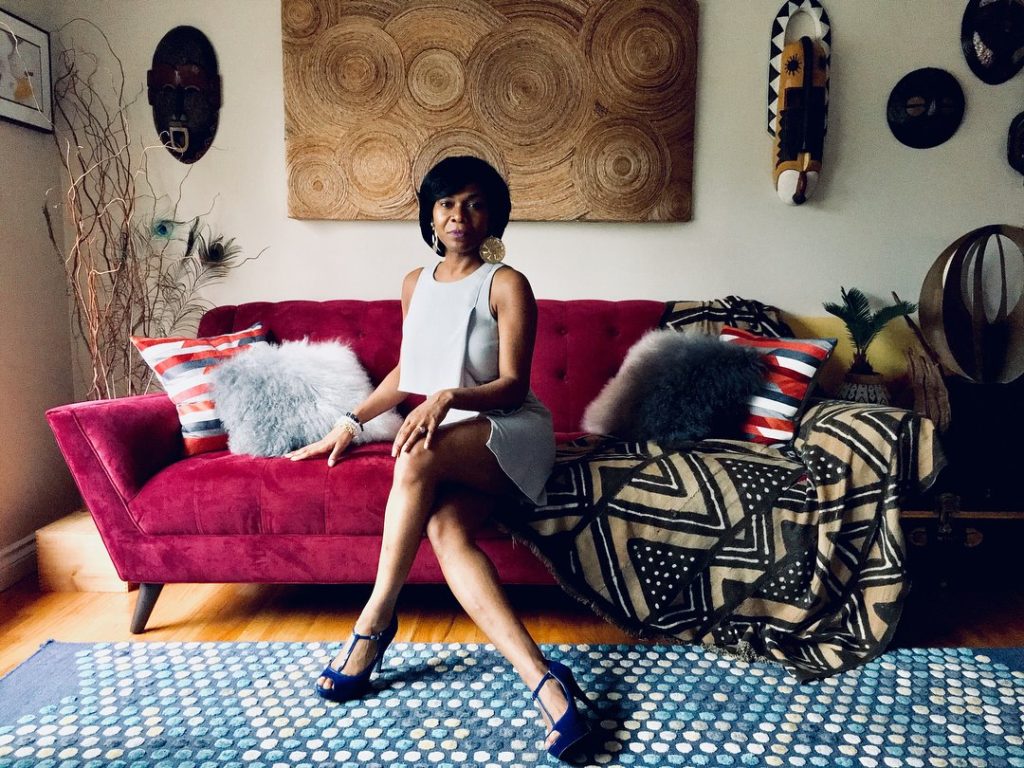 Jacqueline M. Baker posing on a couch to help a friend with their photography project